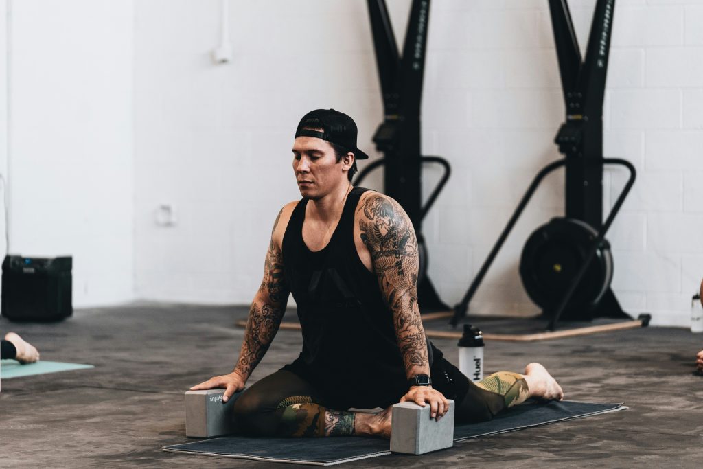 man performing a static stretch in pigeon pose